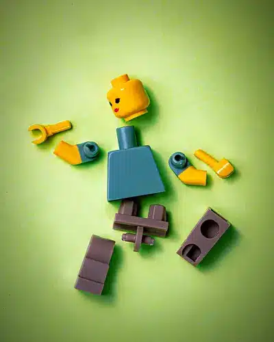 Image of a Lego minifig in pieces representing human social dynamics, relationships and breakups.